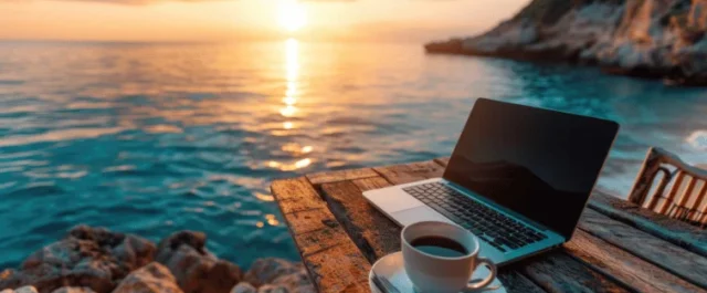Laptop on a table next to the sea