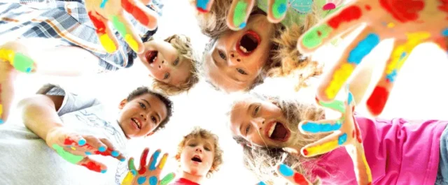 Children showing their painted hands to the camera