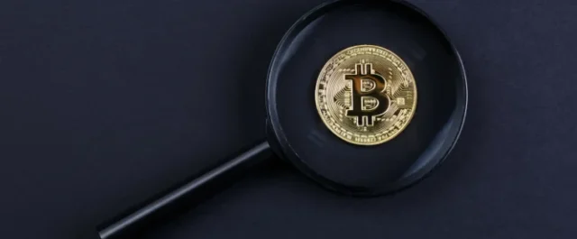 A magnifying glass that zooms in on a bitcoin