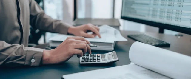 Person am PC mit Dokumenten