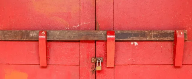 Ein großen rotes Tor mit einem Riegel davor