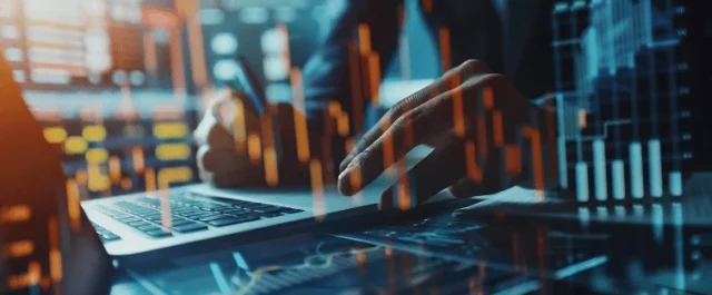 Person am Laptop mit digitalen Graphen und Diagrammen